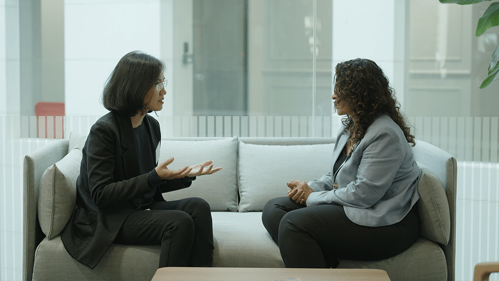CEDR-2-female-Mediation-Professionals-sit-on-a-grey-sofa