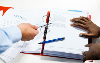 Two hands pointing at documents in a folder