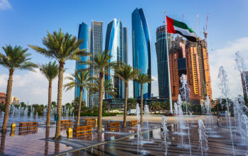 Dubai sky scrapers with flag and water fountain