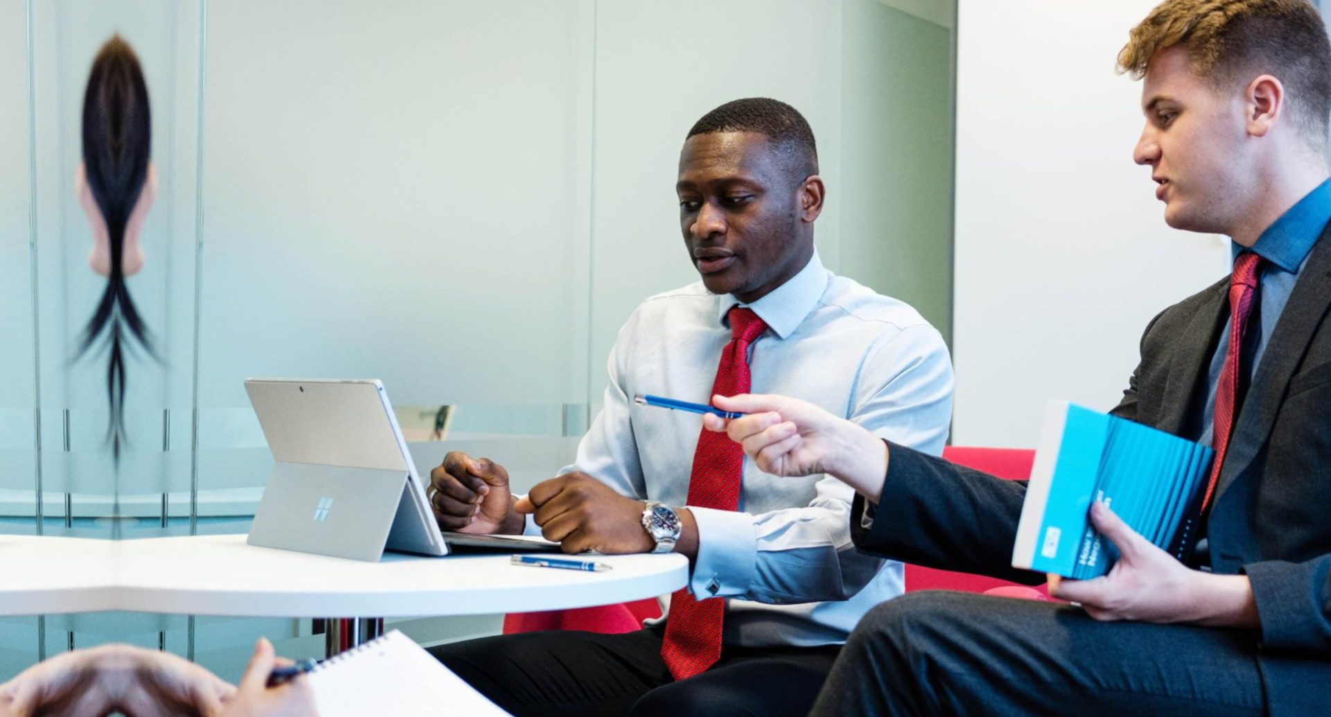 Two people meeting while glancing at laptop screen