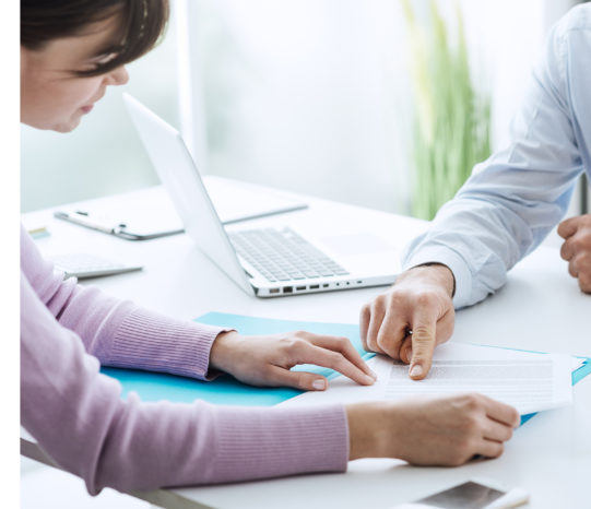 Two people pointing at document